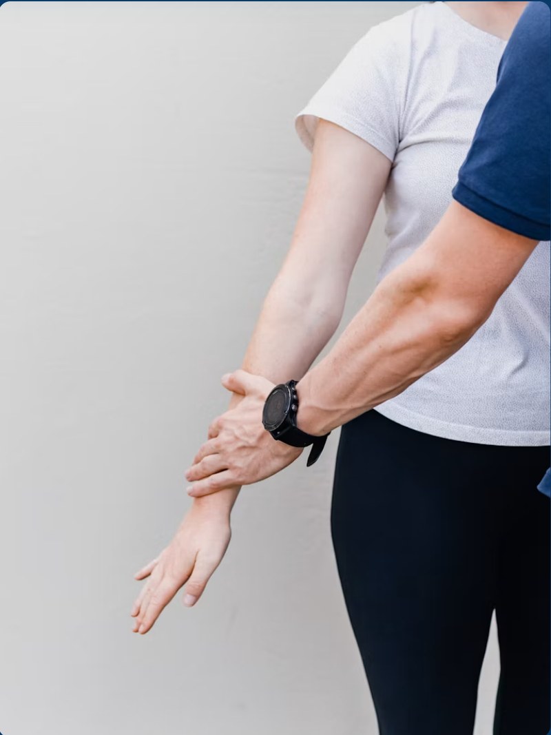 A therapist assessing a patient’s forearm and wrist mobility.